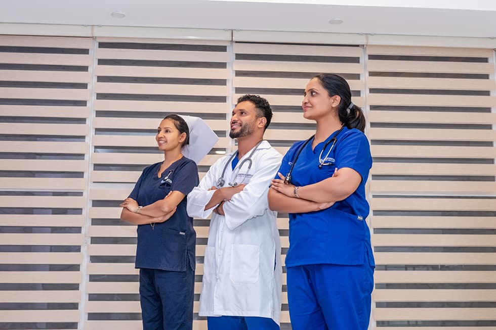 Three St. Joseph Hospital clinicians in branded scrubs standing together