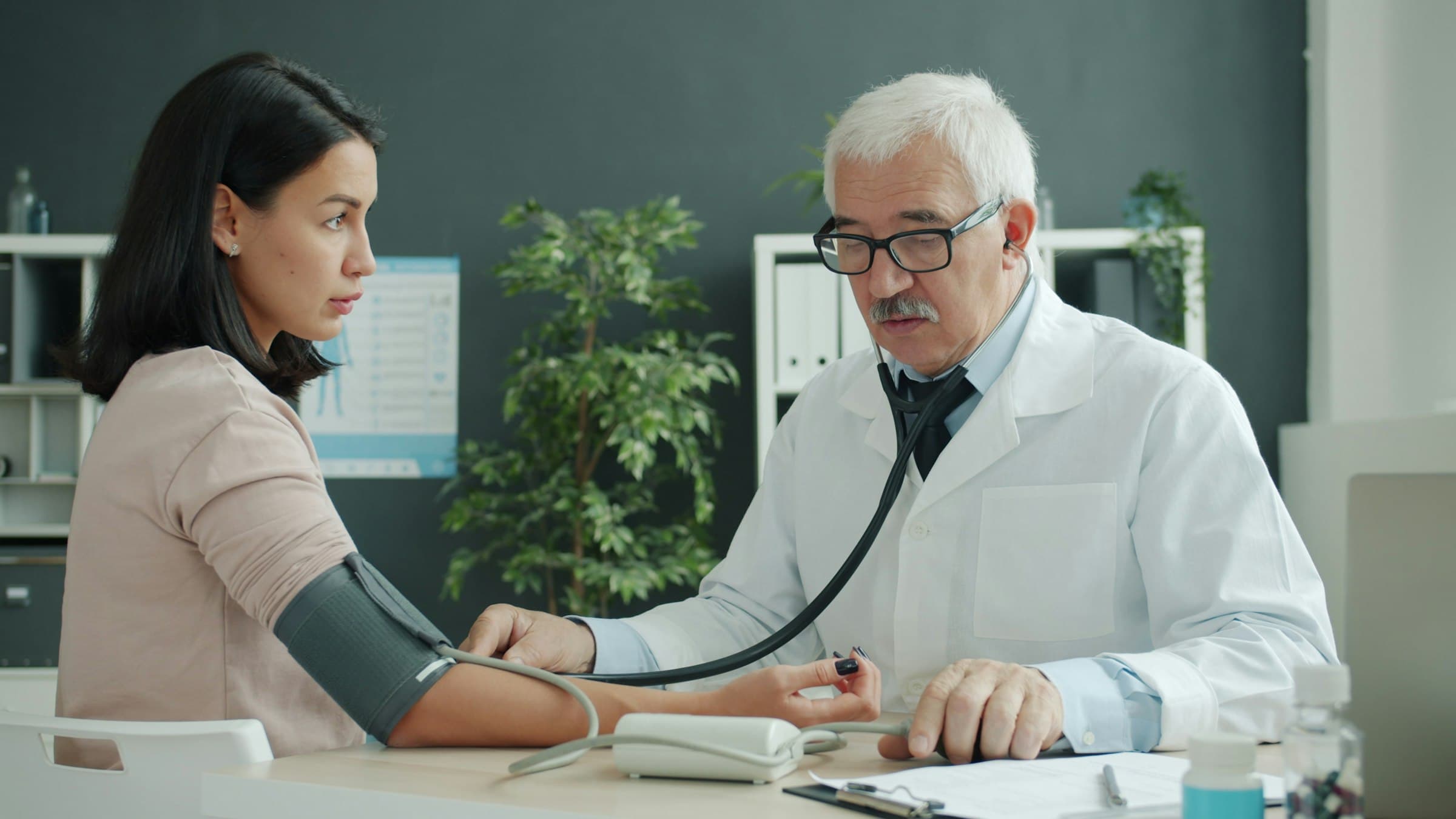 A doctor checking a patient's blood pressure during a consultation