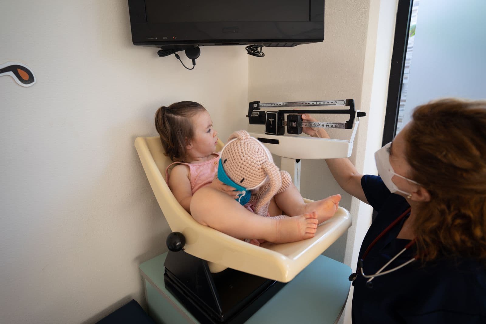 A child being weighed on a scale during a paediatric check-up