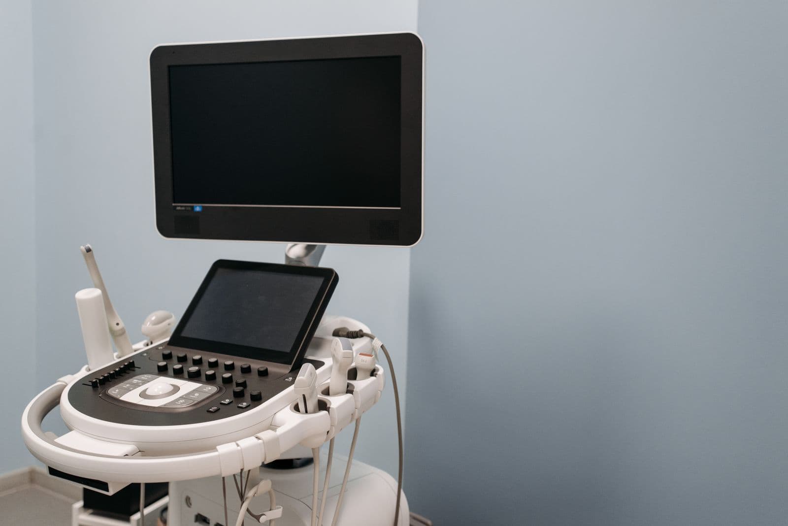 An ultrasound machine console in a clinic examination room