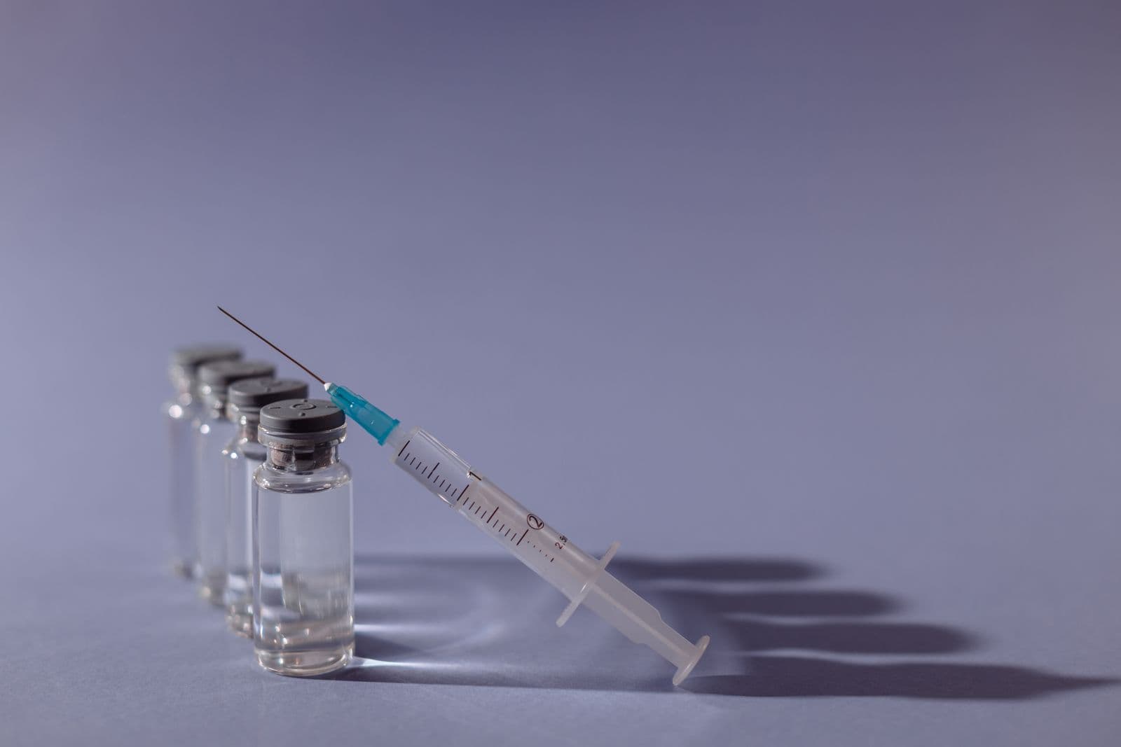 A syringe and vaccine vials arranged on a table
